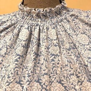 Blue and white patterned shirt. Flare bottom and ties in back of neck. Polyester